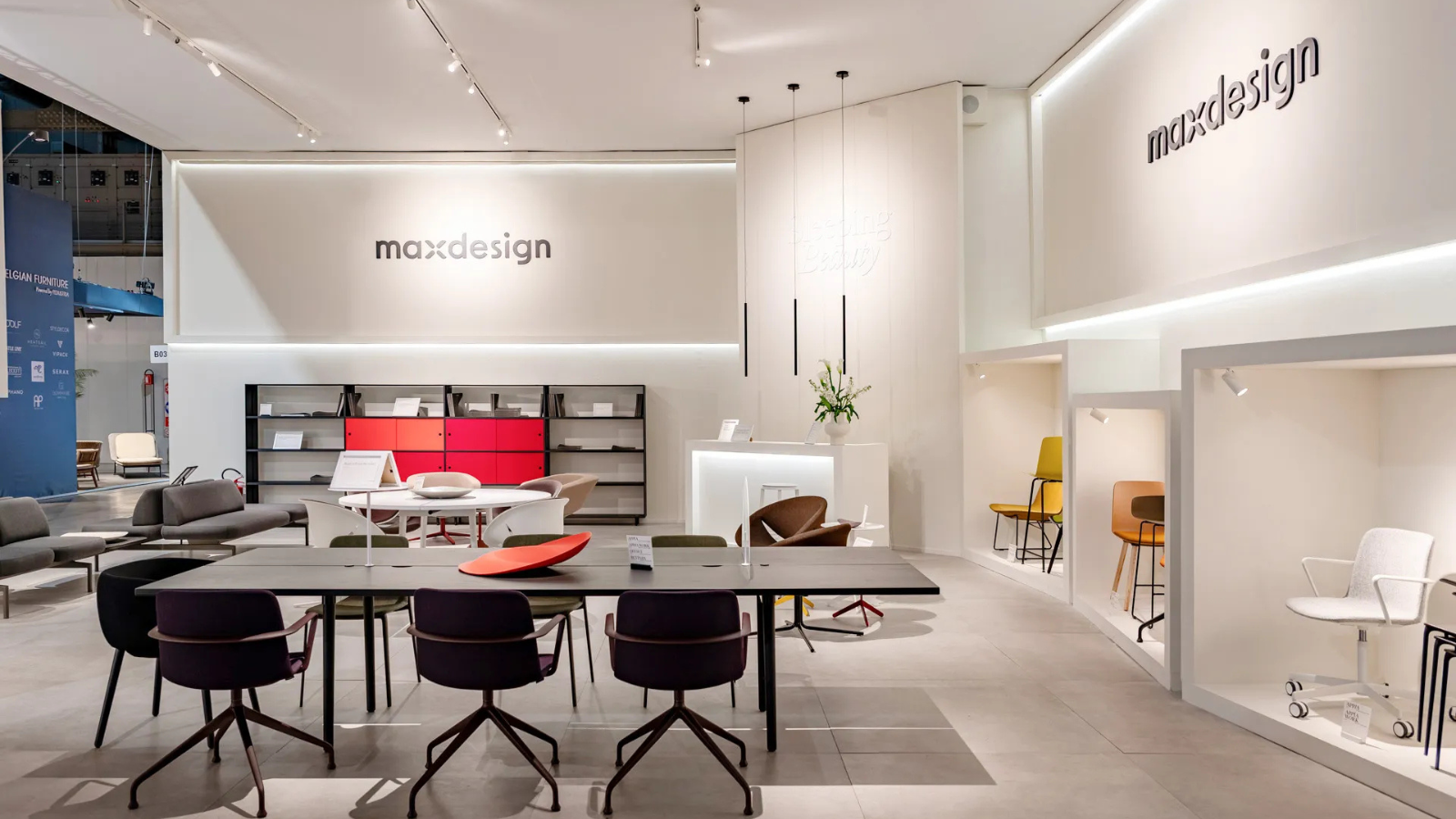 Ufficio maxdesgin l'ufficio è bianco con sedie e tavoli marroni scuro e qualche mobile rosso