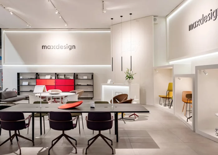 Ufficio maxdesgin l'ufficio è bianco con sedie e tavoli marroni scuro e qualche mobile rosso